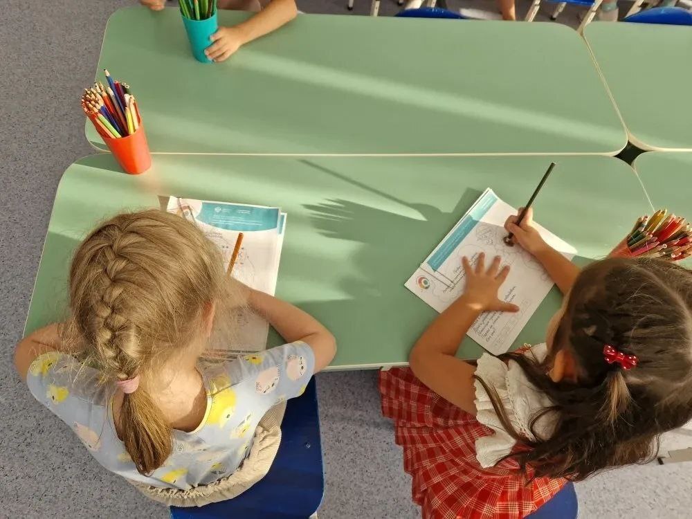 На фото дети выполняют за столом задания