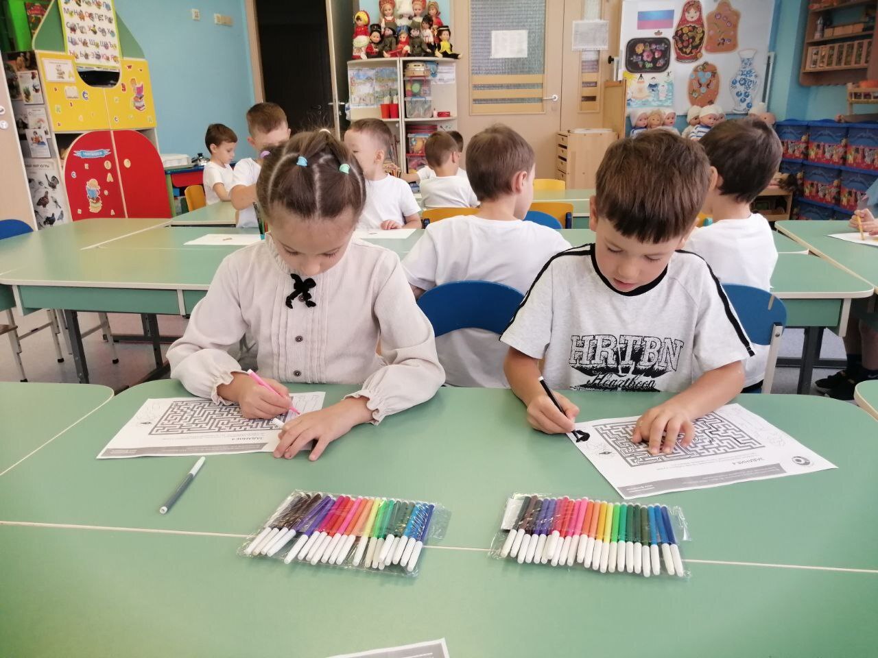 На фото дети выполняют за столом задания