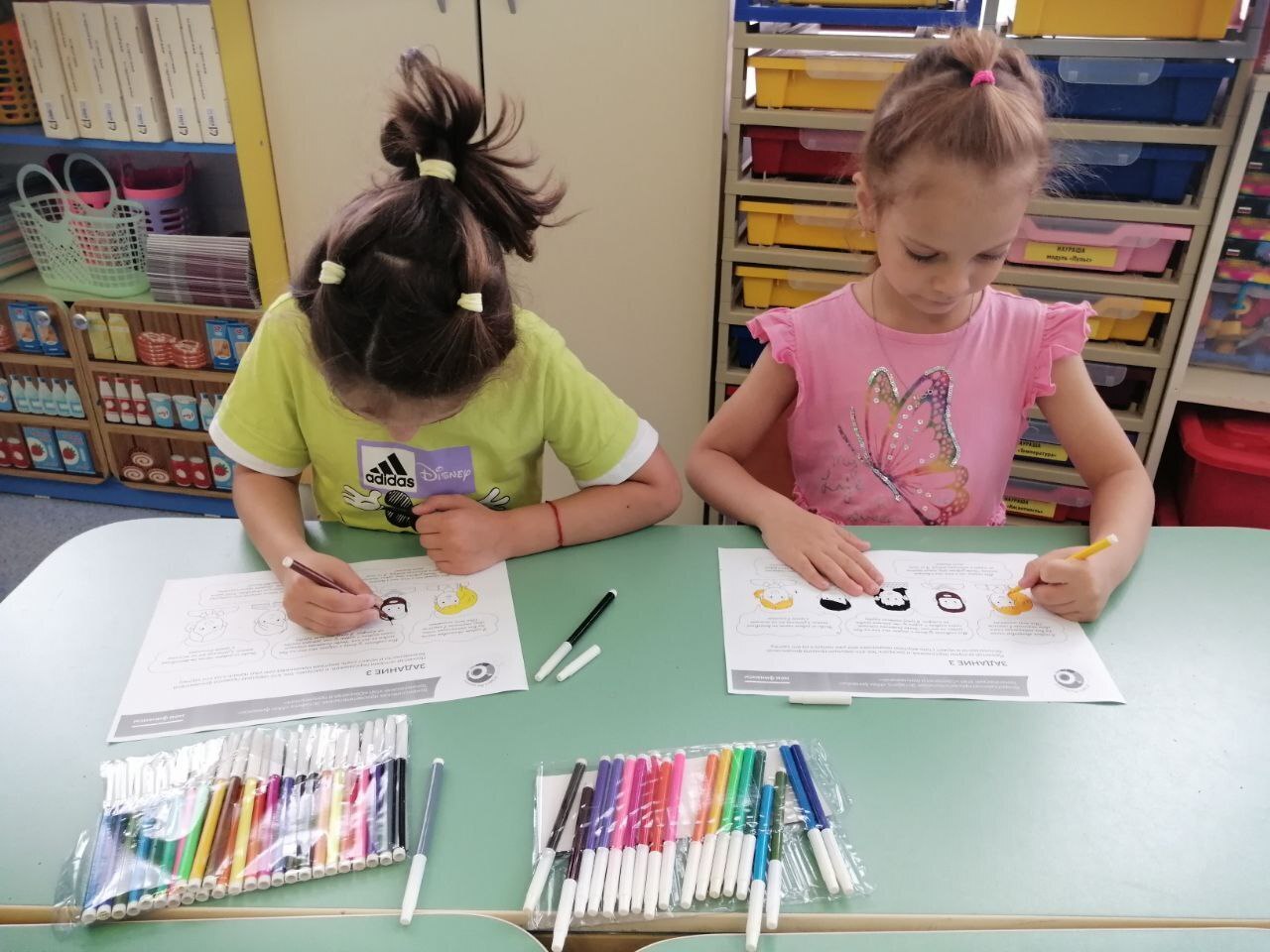 На фото дети выполняют за столом задания