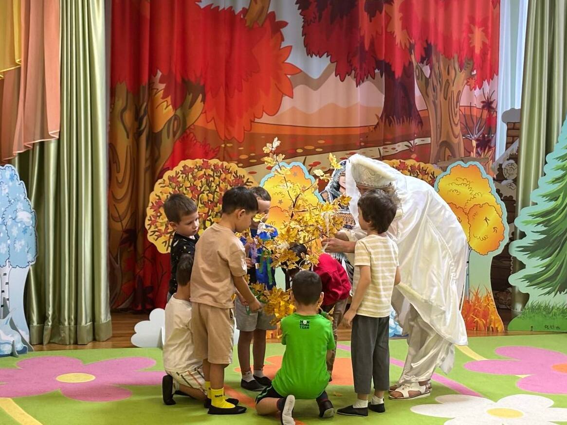 Дети вешают ленточки на дерево