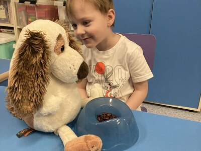 Ребенок кормит собаку-игрушку