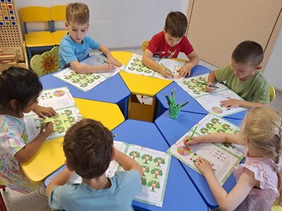 На фото дети выполняют задания в рабочих тетрадях по дополнительной программе  Логика для малышей