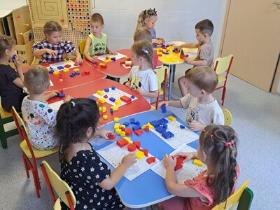 На фото дети выполняют задания с логическими блоками Дьенеша